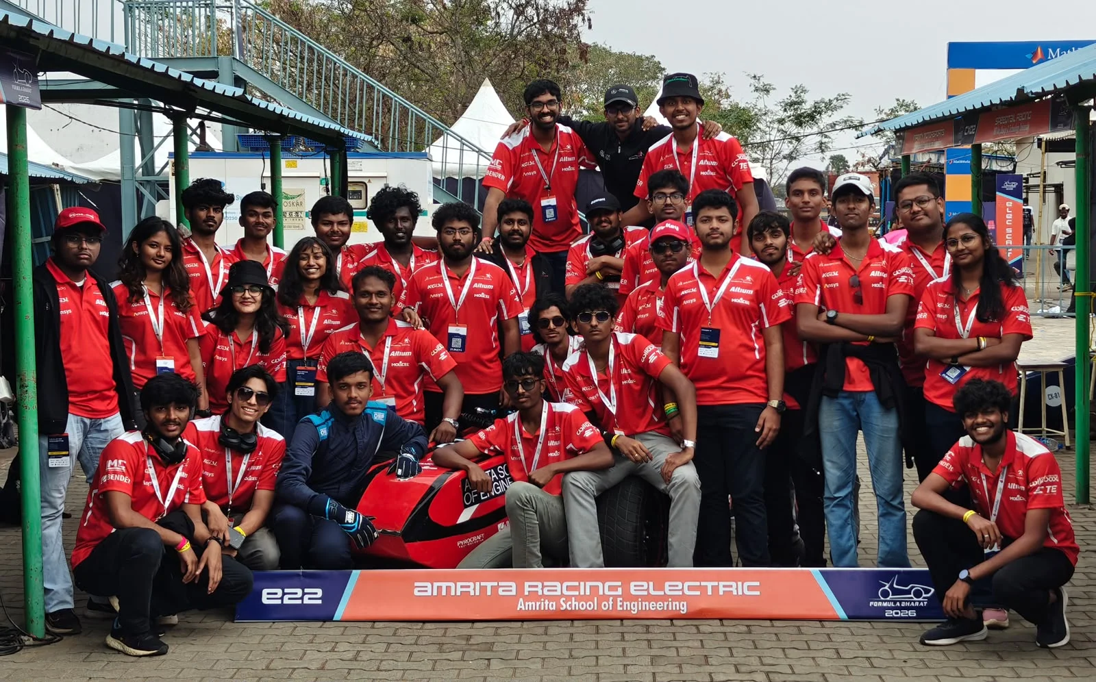 Amrita Racing Electric team in custom red apparel with their race car